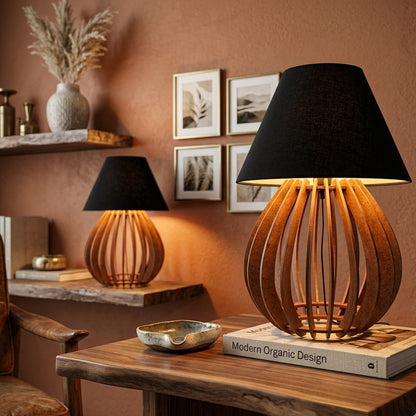 Luminária de mesa com cúpula preta acesa em um canto com quadros na parede